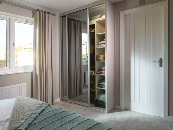 Built in wardrobe in a Persimmon bedroom