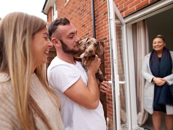 Young couple showing off their new puppy