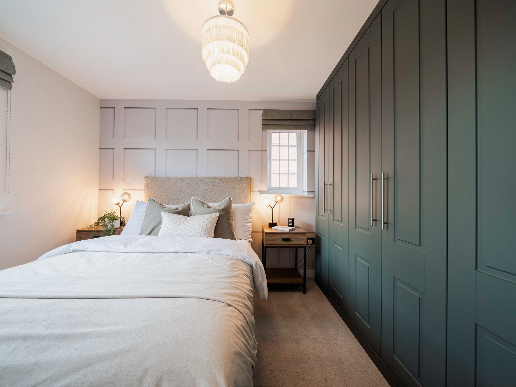 A modern bedroom in a new build Persimmon home with built in green wardrobes